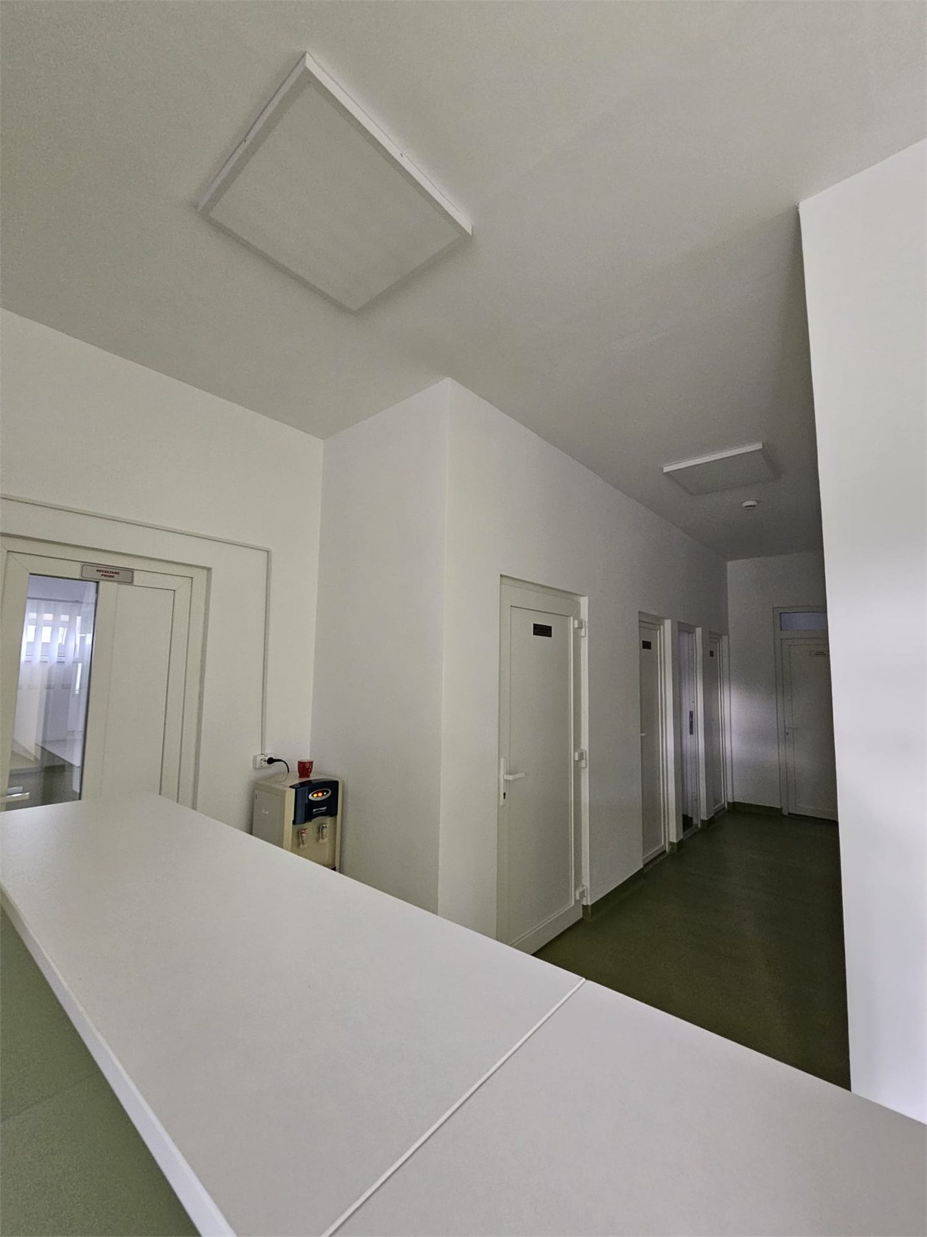 Zona de receptie alba intr-un spatiu medical finalizat